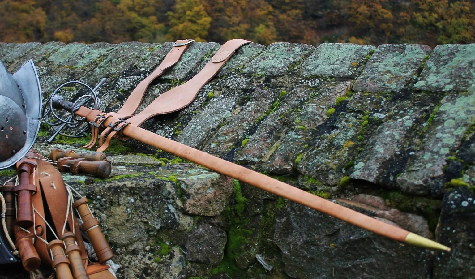 Rapier, Bandelier und historische Ausrüstung auf einer alten Steinmauer