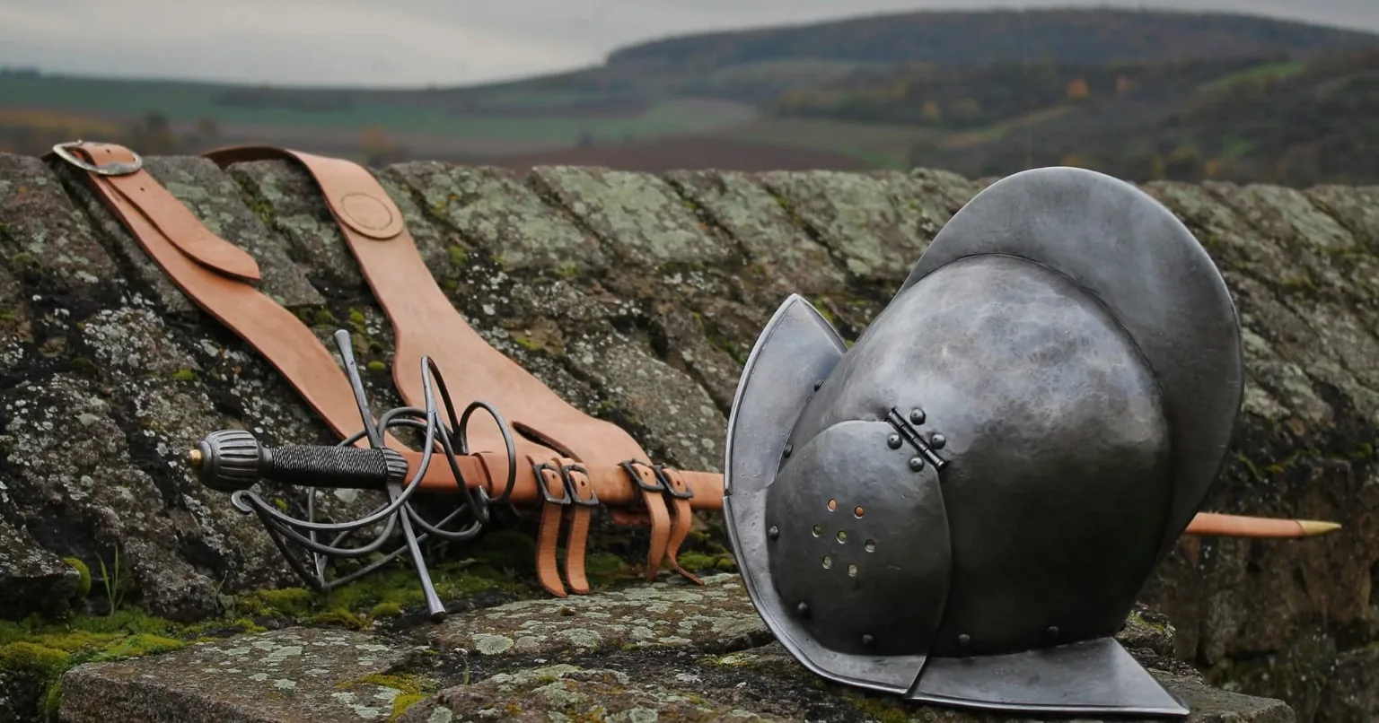 Morionhelm, Rapier und Bandelier auf altem Mauerwerk